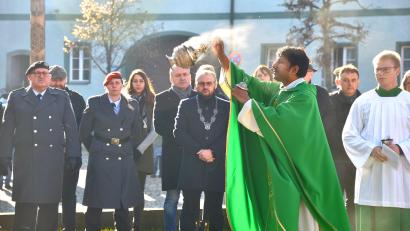 Bild: fjo
Pater John Gali beschließt mit Weihrauch und Weihwasser die Segensandacht am Kriegerdenkmal nach der Kranzniederlegung durch Stephan Mathy und Anna Gottinger (von links).