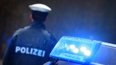 Symbolbild: Karl-Josef Hildenbrand
Ein Polizist steht im Regen vor einem Streifenwagen. Die Beamten haben den Verdächtigen ermittelt, der in einer Regensburger Unterkunft für Asylsuchende zwei Frauen sexuell belästigt haben soll.