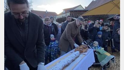 Bild: Stadt Waldsassen/exb
Beim Weihnachtsmarkt schnitten die beiden Bürgermeister Patrik Pitzinger (links) und Bernd Sommer die beiden Stollen an; die Stücke wurden wenig später an die Gäste aus der Partnerstadt und an die Besucher aus Waldsassen verteilt.