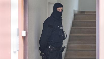 Symbolbild: Boris Roessler
Bei einer Razzia gegen sogenannte "Reichsbürger" sichert ein Polizist ein durchsuchtes Objekt.