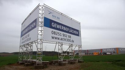 Archivbild:  Ulf Vogler/dpa 
Ein großes Transparent wirbt für den «Acht 300 Gewerbepark», ein gemeinsames Projekt der Stadt Aichach und der Gemeinde Dasing.