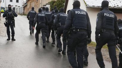 Bild: Bodo Schackow/dpa/Archivbild
Einsatzkräfte der Polizei laufen während einer Durchsuchung zum Jagdschloss Waidmannsheil.