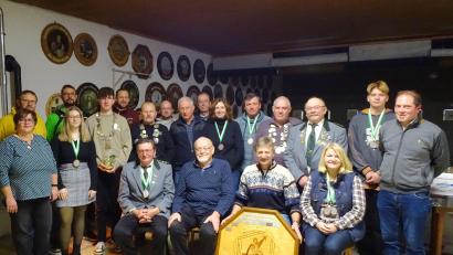 Bild: fjo
Die große Weihnachtsscheibe 2022 aus der Intarsien-Werkstatt von Willi Helgert (sitzend, Zweiter von links) ließ sich Hermann Meier (rechts daneben) beim Scheiben- und Pokalschießen der 1864er-Schützen nicht entgehen .