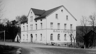 Bild: Archiv Walter Schraml/exb
Die Aufnahme aus der Zeit vor 1919 zeigt das ursprüngliche „Stammhaus“ der Familie Johann Rösch vor der Erweiterung. Auch im „Solo-Zustand“ machte das Gebäude mit dem Gasthaus Zur Eisenbahn im Erdgeschoss einen stattlichen Eindruck. Zuletzt in „Poststüberl“ umbenannt, endete dann Jahre später die Gasthaustradition am Bahnhofsvorplatz.