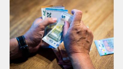 Symbolbild: Lino Mirgeler/dpa
Ein älterer Mann zählt Geld an einem Tisch.