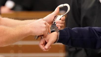 Symbolbild: Thomas Frey
Einem Mann werden die Handschellen angelegt.