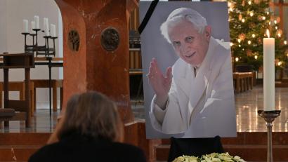 Bild: Katrin Requadt/dpa
Eine Frau betet in der Frauenkirche in München vor einem Bild des verstorbenen emeritierten Papst Benedikt XVI.