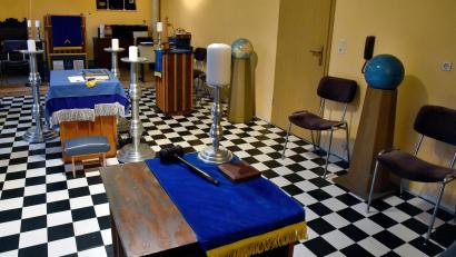 Bild: Stephan Huber
Alle Freimaurertempel sind nach gleichem Muster aufgebaut. Mit dem Zeremonienhammer ruft der Meister vom Stuhl Brüder zur Ordnung. Auf dem Altar in der Mitte liegt die Bibel mit den Symbolen Zirkel und Winkelmaß auf. Die drei Kerzen um den Altar sollen den Sonnenlauf symbolisieren: Weil sie im Norden nie steht, fehlt die vierte Kerze.