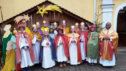 Bild: jow
Die Sternsinger vor der Krippe bei der Pfarrkirche St. Walburga in Lintach mit Pfarrer Moses Gudapati.