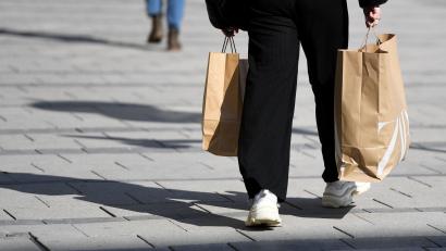 Symbolbild: Angelika Warmuth/dpa
Eine Frau schlendert mit Einkaufstüten von einem Modegeschäft durch die Stadt.