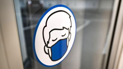 Symbolbild: Felix Kästle/dpa
Ein Aufkleber an einer Glastür weist auf das Tragen einer Maske hin.