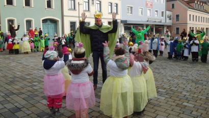 Bild: u
Nachdem ihm die Krawatte abgeschnitten worden ist, verzaubern zwei kleine Feen Bürgermeister Hermann Falk in einen Frosch. So kostümiert tanzt er mit den Kindern.