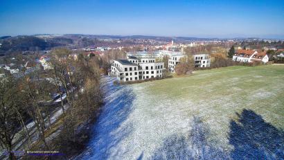 Bildmontage: Sabine Wiederer, Dipl.-Ing. (FH)/exb
In der dreidimensionalen Visualisierung sind in der Perspektive von der Felixkirche aus die geplanten Häuser auf dem ehemaligen Krankenhausareal in Neustadt/WN vor der Kulisse des Stadthügels zu sehen. Links verläuft die Felixallee