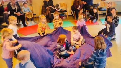 Bild: Ann-Kathrin Förderreuther/exb
Mit Tüchern spielen die Kinder die biblische Geschichte von der Stillung des Sturms nach.