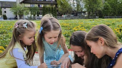 Bild: Khrystyna Arsenova 
Ein Bild, wie gemalt: Tatsächlich haben die ukrainischen Familien mit ihren teils noch kleinen Kindern im Josefhaus in Hirschau (im Hintergrund) neben den Schrecken des Krieges ein Stück Idylle und Geborgenheit gefunden - auch dank der guten Betreuung und Ablenkung vor Ort wie hier beim Basteln mit Blumen auf der Wiese.