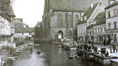 Bild: Stadtarchiv Amberg / exb
Blick auf die Schiffgasse in Amberg um 1900. Deutlich sind die hölzernen Fischkästen in der Vils zu erkennen, in denen die Fischhändler nach dem Abfischen der Weiher ihre Ware aufbewahrt haben. Zu sehen sind auch die hölzernen Kähne, mit denen die Fischer ihrer Arbeit nachgingen oder die sich junge Leute mieteten, um auf der Vils zu fahren.