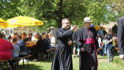Archivbild: ads
2018 schlenderte Pfarrer Markus Brunner mit Bischof Rudolf Voderholzer zum Patrozinium über den Pfarrgarten. Heuer kommt der prominente Gast zum Pfarrjubiläum von St. Georg erneut.