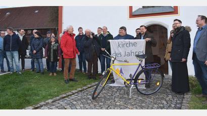 Bild: no
Der 1. Vorsitzende des Fördervereins Simultankirchen in der Oberpfalz, Hans-Peter Pauckstadt-Künkler (rote Jacke), und Sulzbach-Rosenbergs 2. Bürgermeister Günther Koller überreichten vor dem Eingang der Filialkirche St. Margareta die Fahne und das Fahrrad an Illschwangs Bürgermeister Dieter Dehling.