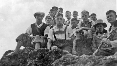 Bild: Archiv tsp
Pfarrer Johannes Seidl (hinten Mitte, mit Nickelbrille) nahm sich der Jugend an. Schon nach wenigen Monaten im Amt machte er Anfang der 1930er Jahre mit der Katholischen Jugend einen Ausflug in seine Heimat auf den Schneiderberg und an den Arber. Mit im Bild der etwa 13 Jahre alte Bepp Steckermeier (Zweiter von links), der diese Fotografie in seinem Fotoalbum aufbewahrt.