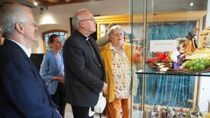 Bild: krb
Stadtpfarrer Josef Häring (von links) bestaunt mit Bischof Rudolf Voderholzer die Passionsausstellung mit Figuren von Maria Mende, die auch die einzelnen Szenen erläutert.