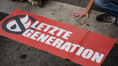 Bild: Swen Pförtner/dpa/Symbolbild
Ein Aktivist der Gruppe „Letzte Generation“ blockiert eine Kreuzung.