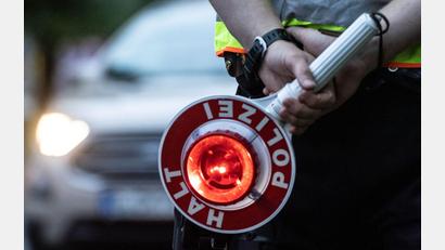 Symbolbild: Paul Zinken/dpa
Ein Polizist hält bei einer Verkehrskontrolle eine Winkerkelle in der Hand.