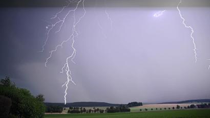 Bild: Marius Bulling/dpa
Ein Blitz zuckt bei einem Sommergewitter am abendlichen Himmel.