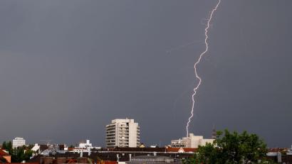 Bild: Peter Kneffel/dpa
Ein Gewitter mit Blitzen zieht in den Abendstunden über die Dächer von München.