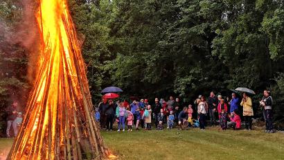 Bild: R. Kreuzer
Das Feuer in Neunkirchen loderte. Pfarrvikar Robert Amandu segnete das Feuer. Viele Gäste wechselten den Platz, zogen von den Bänken und Tischen mit an das brennende Feuer.