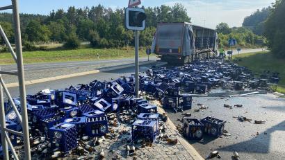 Bild: --/Polizeiinspektion Kulmbach/dpa
Bierkisten liegen nach einem Unfall an der Fahrbahn.