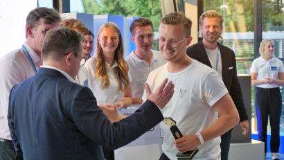 Bild: jut
Der Sieger des Start-up-Wettbewerbs, Florian Dostert (mit Brille, im weißen T-Shirt), nimmt Glückwünsche an. Im Hintergrund freuen sich TV-Investor Tillman Schulz sowie Thomas und Pauline Engel.