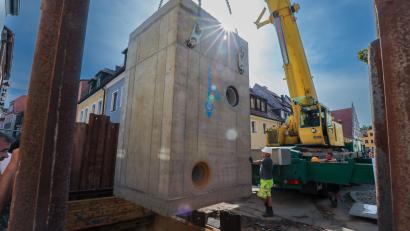 Bild: Wolfgang Steinbacher
32 Tonnen Stahlbeton im Gegenlicht. Das Kanal-Kreuzungsbauwerk wurde am Mittwoch mit einem Autokran in der Paulanergasse eingehoben.