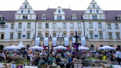Bild: Armin Weigel/dpa
Besucher der Schlossfestspiele sitzen im Garten vor dem Fürstenschloss St. Emmeram.