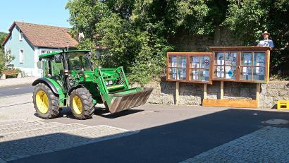 Bild: bsc
Roland Mitlmeier (rechts hinter dem Schaukasten) vom Bauhof der Gemeinde Friedenfels brachte die Info-Kästen am neuen Standort vor der Grundschule in Position.