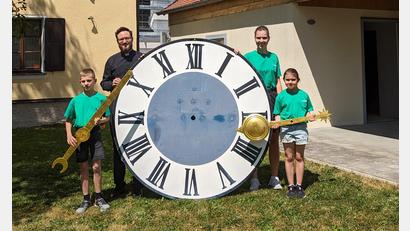 Bild: Manuela Popp/exb
Pfarrer Johannes Arweck und Oberministrantin Theresa Popp mit den jüngsten Minis Tim und Isabella vor dem großen Ziffernblatt der Ursensollner Kirchturmuhr