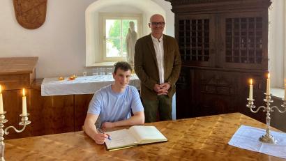 Bild: Andreas Immervoll/exb
Daniel Roiger trägt sich ins Goldene Buch des Marktes ein.