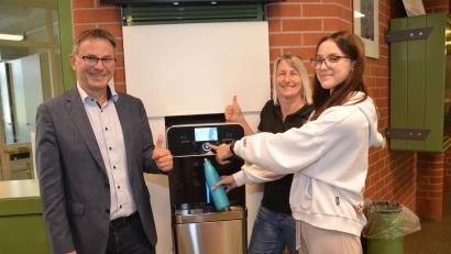 Bild: dob
Schülersprecherin Valentina Hammer (rechts) zapft im Beisein der Vorsitzenden des Fördervereins der Mittelschule, Anja Schaller, und Rektor Hubert Reil frisches Sprudelwasser in eine Trinkflasche. Das ressourcenschonende Gerät kommt bestens bei den Schülern an.