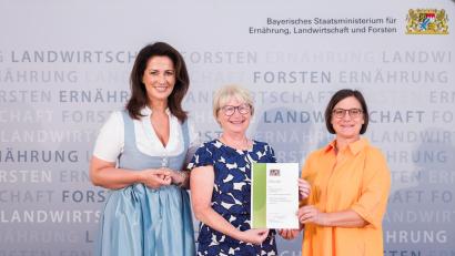 Bild: Hauke Seyfarth/StMELF/exb
Tanja Schornbaum (rechts) vom Stiftland-Gymnasium und Coach Angelika Meindl (Mitte) mit der Urkunde, die ihnen Ministerin Michaela Kaniber überreicht hatte.