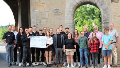 Bild: Dagmar Williamson 
Alexander Färber, Benjamin Färber und ihre Auszubildenden, das "Juniorteam" (rechts) übergeben 10.000 Euro an die Schweppermann-Stadtgruppe der KSJ Amberg und ihre Vorstände. Geplant für die Jubiläumsfeier ist auch eine Führung durch Innenleben des Ziegeltors, dem Hauptsitz ihres Treffpunktes.