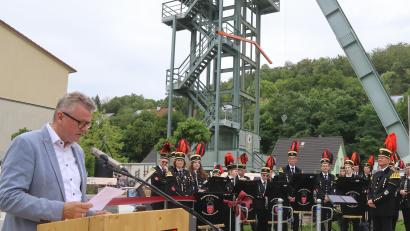 Bild: mfh
Bürgermeister Michael Göth und die Bergknappenkapelle bei der Feierstunde zu Füßen des Förderturms auf St. Anna.