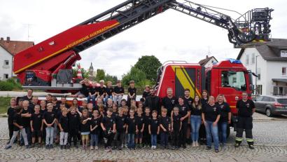 Bild: lei
Glücklich posieren die Mädchen und Buben der Kinderfeuerwehr Auerbach zum ersten Mal mit ihren neuen T-Shirts vor der Drehleiter.