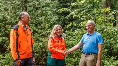 Bild: Martin Hertel/exb
Winfried Pfahler (links), Leiter des Forstbetriebs Fichtelberg, begrüßt mit dem scheidenden Revierleiter Hermann Kießling (rechts) dessen Nachfolgerin Katharina Bäcker als neue Försterin an der Kösseine.