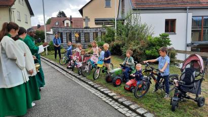 Bild: Braun/exb
Tretbulldogs, Bobbycars und Fahrräder werden in Altendorf von Pfarrer Johnson Varakaparambil gesegnet.