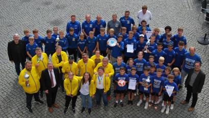 Bild: gsp
Das obligatorische Bild der geehrten Teams vom Rathaus-Balkon aus. In Blau die Teams des SV Raigering, in Gelb die Basketballer der Lebenshilfe.