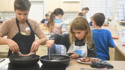 Bild: Gabi Schönberger
Die Kinder braten in der "Burgerwerkstatt" selbstgemachte Patties und Speck an.