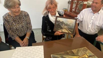 Bild: ck
Maria Poblotzki (Mitte) übergibt im Pleysteiner Stadtmuseum ein bislang unbekanntes Bild ihres Vaters Siegfried Poblotzki, das er während seiner Gefangenschaft in Frankreich gemalt hatte. Grete Reger vom Museumsarbeitskreis (links) und Bürgermeister Rainer Rewitzer (rechts) freuen sich über das Geschenk.
