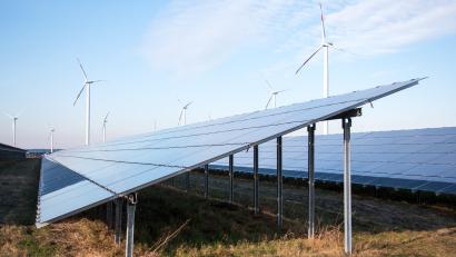 Bild: Daniel Bockwoldt/dpa
Blick auf einen Solarpark, im Hintergrund sind Windräder zu sehen.