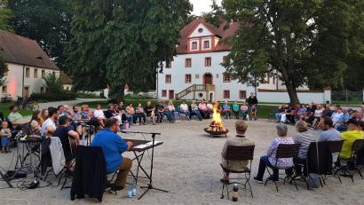 Bild: VG Kemnath/exb
Bürgermeister Hans Walter (Vorne am Mikrofon) erzählte im Schlosshof Wolframshof Lagerfeuergeschichten und regionale Sagen.