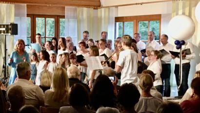 Bild: Michael Luber/exb
Als Gemeinschaftschor singen die beiden Chöre Happy Voices (Hintergrund) und Herzwärts (Vordergrund) zwei Zugaben. Die Chorleiterin von Herzwärts, Gertrud Siegert (links) moderiert den Abend, die Chorleiterin von Happy Voices, Andrea Eichenseer (ganz rechts, mittlere Reihe), hat sich in den Chor eingereiht.