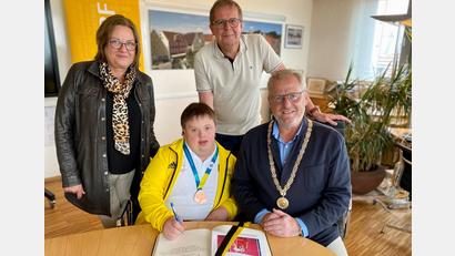 Bild: Stadt Schwandorf/exb
Alexander Harrieder trägt sich im Beisein seiner Eltern Brigitte und Peter Harrieder in das Goldene Buch der Stadt Schwandorf ein. Oberbürgermeister Andreas Feller gratuliert zum Team-Erfolg bei Special Olympics.